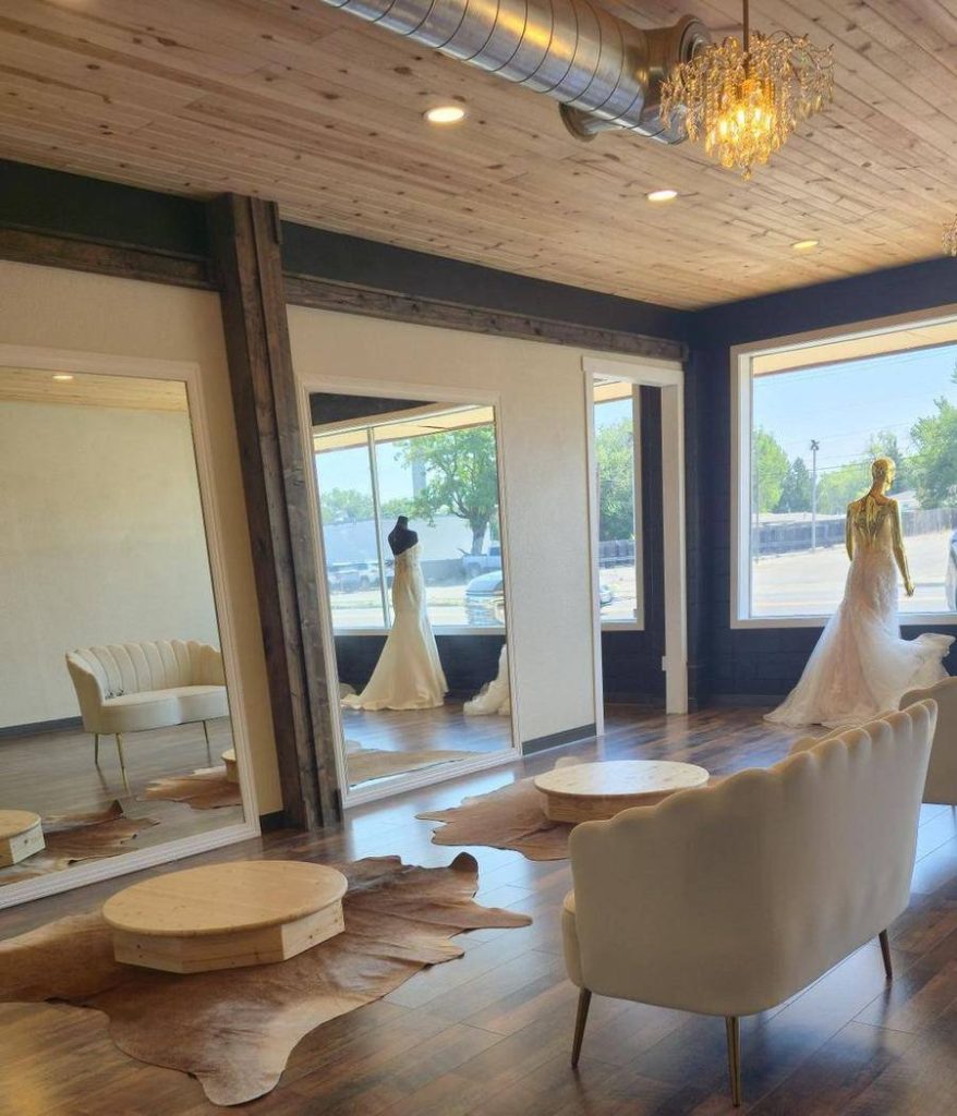 House of Avery Bridal salon interior with reclaimed wood walls, floor-to-ceiling mirrors, cowhide rugs and a fitting pedestal
